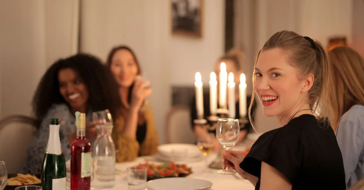 Un groupe joyeux de femmes profitant d'un dîner aux chandelles, célébrant l'amitié à l'intérieur.